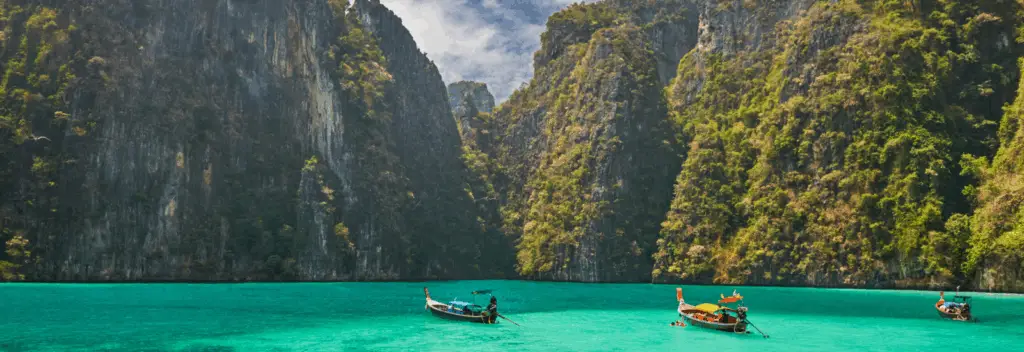 Strand auf Phuket mit Felden und Longtail-Booten