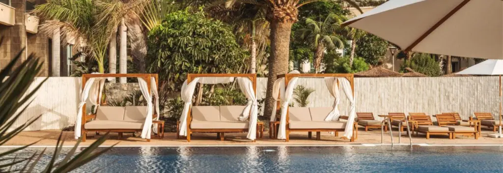 Ein Pool mit drei Sonnenbetten