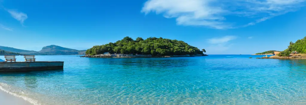 Meer/Strand in Albanien mit einer Insel im Wasser und Bergpanorama