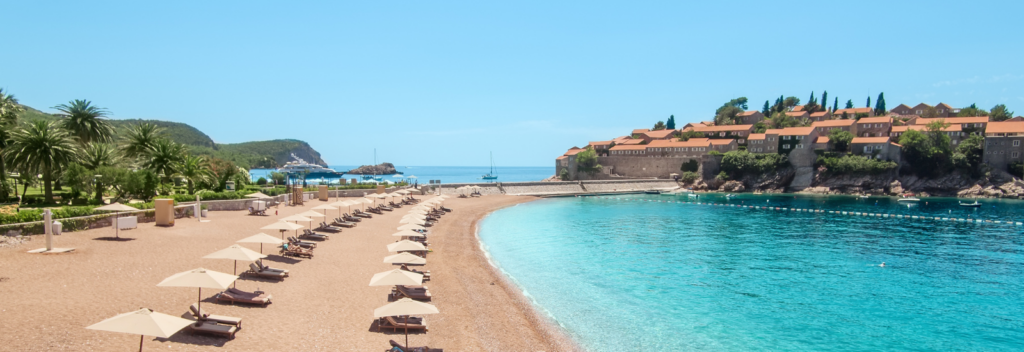 Strand mit Liegen in Montenegro, Meer und felsiges Panorama, Halbinsel im Meer