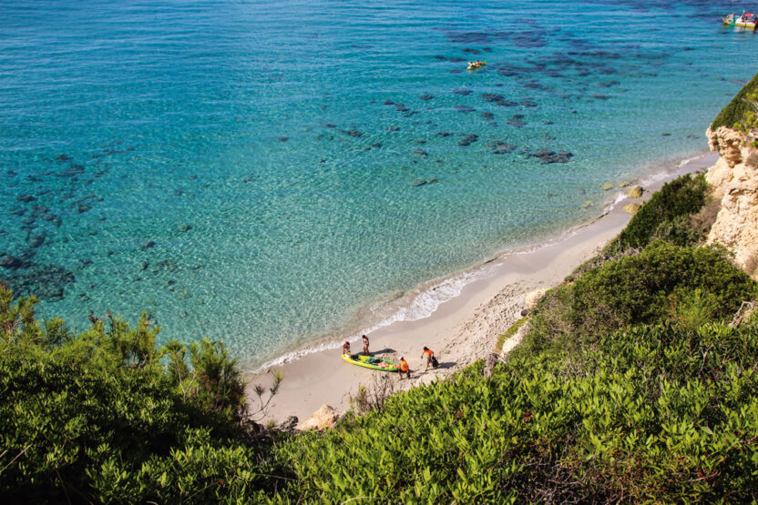 Strand in Menorca mit Menschen und Kajak