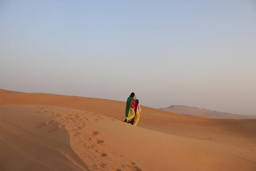 Zwei Personen laufen durch die Wüste von Dubai