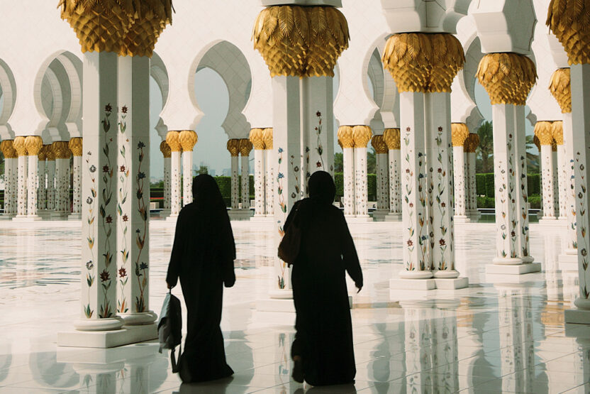 Zwei Personen laufen durch die Sheikh Zayed Moschee